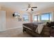 Bedroom with ceiling fan, television, unmade bed, and sliding glass door to deck at 13810 Celida Ave, Hudson, FL 34667