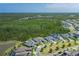 Expansive aerial view showcasing a meticulously landscaped home with a bordering serene lake and lush green surroundings at 16557 Acoustic Loop, Land O Lakes, FL 34638