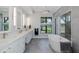 Bright bathroom featuring a large soaking tub, and double vanity with elegant lighting at 16557 Acoustic Loop, Land O Lakes, FL 34638