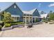 Exterior of the community clubhouse featuring a metal roof, blue siding, and a motorcycle at 16557 Acoustic Loop, Land O Lakes, FL 34638