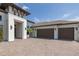 Home featuring a brick driveway, large garage, and a modern stucco facade at 16557 Acoustic Loop, Land O Lakes, FL 34638