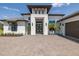 The house has a brick driveway leading to a covered entrance with a well-kept landscaped yard at 16557 Acoustic Loop, Land O Lakes, FL 34638