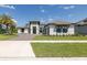 Beautiful home featuring a brick driveway, well-manicured landscaping, and a spacious front yard at 16557 Acoustic Loop, Land O Lakes, FL 34638