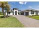 The beautiful home features a brick driveway, pristine landscaping, and a spacious two-car garage at 16557 Acoustic Loop, Land O Lakes, FL 34638