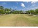 Large community green space surrounded by walking trails, landscaping, and the clubhouse at 16557 Acoustic Loop, Land O Lakes, FL 34638