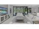 Bright living room with stylish decor, tile floors, and a view of the screened-in pool at 16557 Acoustic Loop, Land O Lakes, FL 34638