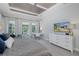 Large main bedroom featuring coffered ceilings, work space, and large dresser with mounted television at 16557 Acoustic Loop, Land O Lakes, FL 34638