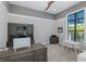 Bright home office with custom built-ins, a large desk, and natural light from a large window at 16557 Acoustic Loop, Land O Lakes, FL 34638