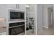 Convenient walk-in pantry with abundant shelving, located next to built-in microwave and oven at 16557 Acoustic Loop, Land O Lakes, FL 34638