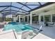 A luxurious screened-in pool area with a spa, water features, and stylish lounging chairs at 16557 Acoustic Loop, Land O Lakes, FL 34638