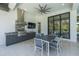 A covered outdoor dining area with a built-in outdoor kitchen and a large flat screen TV at 16557 Acoustic Loop, Land O Lakes, FL 34638