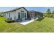 Exterior of the house with screened-in pool, outdoor seating, and verdant backyard at 16557 Acoustic Loop, Land O Lakes, FL 34638