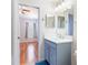 Bathroom with a vanity with mirror, light fixture, and hardwood-floored bedroom in the background at 18353 Briar Oaks Dr, Hudson, FL 34667