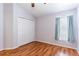 Well-lit bedroom features wood floors, closet, and window with blinds and curtains at 18353 Briar Oaks Dr, Hudson, FL 34667