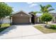 Attractive home featuring a spacious driveway, neutral exterior, and well-manicured landscaping for enhanced curb appeal at 18353 Briar Oaks Dr, Hudson, FL 34667
