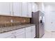 Close-up of granite countertops and stainless steel refrigerator in kitchen at 18353 Briar Oaks Dr, Hudson, FL 34667