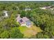 An aerial view of a charming property boasting mature trees, screened lanai, spacious backyard and solar panels at 18502 Winding Oaks Blvd, Hudson, FL 34667