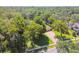 Overhead view of a home with a brick driveway amidst lush, mature trees, creating a private and serene setting at 18502 Winding Oaks Blvd, Hudson, FL 34667