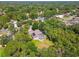 A picturesque aerial view shows a house with a pool, trees, solar panels, and the charm of a quiet neighborhood at 18502 Winding Oaks Blvd, Hudson, FL 34667