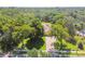 Beautiful aerial view of home featuring solar panels nestled among lush trees with a brick paver driveway at 18502 Winding Oaks Blvd, Hudson, FL 34667
