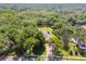 Areal shot of home featuring solar panels and a screened in pool surrounded by mature trees offering peace and privacy at 18502 Winding Oaks Blvd, Hudson, FL 34667