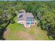 Beautiful aerial shot of a property showcasing a pool, screened lanai, mature landscaping, and a well-maintained lawn at 18502 Winding Oaks Blvd, Hudson, FL 34667