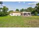 Large backyard featuring a screened lanai, outdoor seating, and well-maintained green space at 18502 Winding Oaks Blvd, Hudson, FL 34667