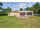 Well-manicured backyard with a screened patio, outdoor seating area, and green lawn at 18502 Winding Oaks Blvd, Hudson, FL 34667