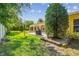Backyard view with a screened-in lanai, patio, grill, and manicured lawn at 18502 Winding Oaks Blvd, Hudson, FL 34667