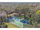 Aerial view of a community basketball court surrounded by trees, with recreational areas visible at 18502 Winding Oaks Blvd, Hudson, FL 34667