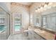 Bathroom showing access door to pool with neutral tones and glass shower at 18502 Winding Oaks Blvd, Hudson, FL 34667
