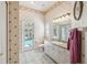 Well-lit bathroom with patterned wallpaper and convenient access to the pool at 18502 Winding Oaks Blvd, Hudson, FL 34667