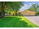 Inviting single-story home with a three-car garage, well-manicured lawn, and a paver driveway at 18502 Winding Oaks Blvd, Hudson, FL 34667