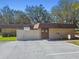 Exterior shot of a building featuring a brick facade, a gated entrance, and well-maintained landscaping at 18502 Winding Oaks Blvd, Hudson, FL 34667