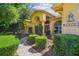 Charming home with manicured shrubbery, lush landscaping, and a brick walkway to the front door at 18502 Winding Oaks Blvd, Hudson, FL 34667