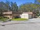 An outside picture of a brick building, displaying an entrance with a gate, signage and manicured shrubbery at 18502 Winding Oaks Blvd, Hudson, FL 34667