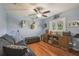 A flex room that is set up for hobbies includes laminate wood floors, a ceiling fan and shuttered window at 18502 Winding Oaks Blvd, Hudson, FL 34667