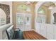 Inviting foyer featuring hardwood floors, archways, and decorative glass front doors at 18502 Winding Oaks Blvd, Hudson, FL 34667