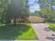 Front exterior view showcasing a brick driveway, well-manicured lawn, and a three-car garage at 18502 Winding Oaks Blvd, Hudson, FL 34667