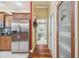 Hallway with kitchen view, pantry, laundry room access and hardwood floors at 18502 Winding Oaks Blvd, Hudson, FL 34667