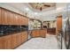 Open-concept kitchen featuring granite counters, tile floors, and stainless steel appliances at 18502 Winding Oaks Blvd, Hudson, FL 34667