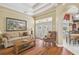 Inviting living room featuring hardwood floors, tray ceiling, and French doors to outdoors at 18502 Winding Oaks Blvd, Hudson, FL 34667