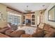 Inviting living room with a ceiling fan, plush sofas, and pool view through the double doors at 18502 Winding Oaks Blvd, Hudson, FL 34667