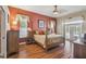 The primary bedroom has hardwood floors, warm paint and a four poster bed that awaits its new owners at 18502 Winding Oaks Blvd, Hudson, FL 34667