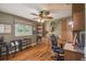 Inviting office featuring custom wooden cabinets, a ceiling fan, and lots of natural light from the large window at 18502 Winding Oaks Blvd, Hudson, FL 34667