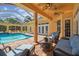 Relaxing covered patio with outdoor seating and a scenic view of the screened pool area at 18502 Winding Oaks Blvd, Hudson, FL 34667