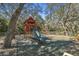 Community playground with a wooden playset, slide, swing set, and safety mulch ground at 18502 Winding Oaks Blvd, Hudson, FL 34667