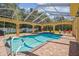 Inviting pool area features brick-paved deck, covered seating, and a fully screened enclosure at 18502 Winding Oaks Blvd, Hudson, FL 34667