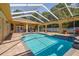 Large screened pool with brick patio, covered seating, and access to the home's backyard at 18502 Winding Oaks Blvd, Hudson, FL 34667