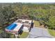 Aerial view of a utility building with a blue water storage tank, surrounded by a wooded area at 18502 Winding Oaks Blvd, Hudson, FL 34667